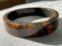Close-up front angle showing the marbled orange and olive Bakelite with smooth glossy finish.