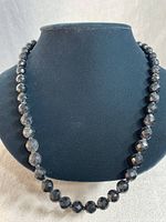 Front view of the vintage French jet faceted beaded necklace on black display bust, showing full necklace length.