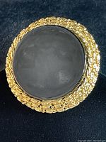 Front and close-up views of the Vintage Grosse brooch showing black stone center and gold-tone twisted rope frame