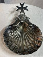 Top-down view showing scallop shell shape and layered curves in silver plate.