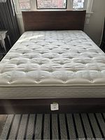 Front view of bed frame and mattress against window