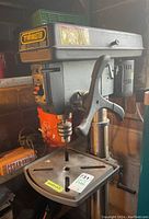 Full view of drill press showing head, feed handle, table