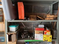 Two-tier metal shelf with assorted tools and cases