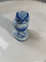 Top-front view showing detailed facial features and blue painted design of the owl figurine.