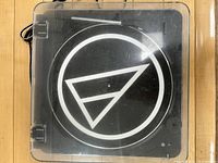 Closed view of the Audio-Technica turntable with clear dust cover showing the logo on the platter and cover.