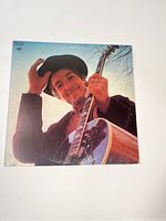 Front cover photo of the Nashville Skyline album showing Bob Dylan smiling with guitar and hat.