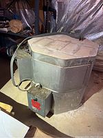 Front view of kiln showing metal exterior, control box and attached power cord