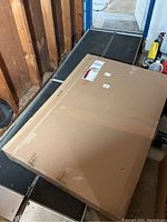 Photo showing new boxed 4 ft aluminum wheelchair ramp with shipping label on box.