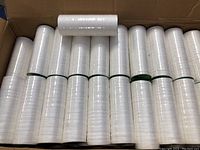 Full box view showing multiple rows of compressed cloth rolls stacked inside a cardboard box.