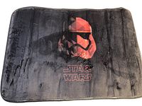 Front view of black bath mat with red Star Wars Stormtrooper helmet design
