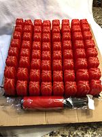 Full view of red air cushion with multiple inflated pods, pump placed underneath