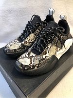 Left side angle of Kenneth Cole women's snake print joggers on box, showing side and front profile.