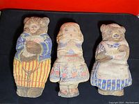 Front view of three antique plush pillows depicting two bears and Goldilocks in printed fabric from Kellogg's 1920s promotion.