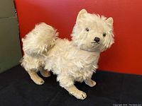 Front and side views of the vintage 1930s Steiff mohair dog with cream colored curly fur and curled tail, showing condition and details.
