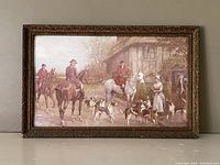 Front view of the vintage coloured fox hunt lithograph framed art. The scene depicts riders on horseback with hunting dogs near a rustic building.