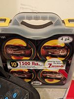 Photo of 4-pack tie down straps with 1500 lbs break strength and quick wind-up feature in a plastic case