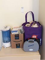 Photo showing Vicks humidifier, box with medical supplies, purple tote with gauze and bandages, two InTENSity Twin Stim Pin machines in cases.