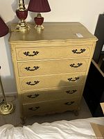 Front view of tall upright dresser showing five drawers, scallop details, metal handles, and Queen Anne legs.