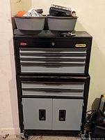 Frontal view of Stanley metal tool chest with two plastic bins on top