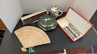 Photo showing entire lot with ceramic bowl, wooden and bone chopsticks, ceramic cup, and folding fan