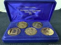 Photo showing the six coins displayed in a blue velvet display box with satin covered lid bearing inscription 'Limited Proof Edition European Architectural Heritage Year 1975'.