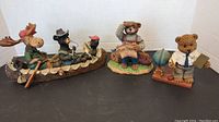 Photo of three resin collectible figures grouped together on black surface showing full lot.