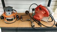 Wide view of the Black & Decker router, Milwaukee circular saw, and vintage hand drill grouped together on a wooden surface.