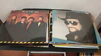 Stacks of vinyl records with visible front album covers including The Oak Ridge Boys and Waylon Jennings.