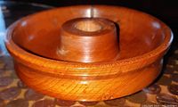 Close-up of the circular hand turned black cherry wood candle holder showing the smooth grain and central candle socket