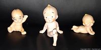 Three Kewpie dolls posing together showing size difference and detail