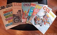 Photo showing all six vintage magazines fanned out on a table. Covers show a range of motorcycle and car imagery from 1967 to 1973.