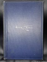 Front cover of the book showing dark blue hardcover with Mark Twain's signature embossed.