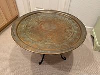 Angled view showing top and part of the black metal base with scroll design.