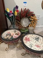 Photo shows two crackled ceramic floral pots on brass stands, a large grain wreath, green ceramic pot, two ceramic cups, and Waterford Marquis vase with wood tulips inside