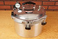 Front angle view of the complete pressure canner cooker showing pot body, lid, gauge and vent