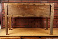 Front view of the antique dry sink showing the rectangular basin and legs with wood grain and construction details.