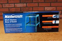 Box showing front label and image of the Mastercraft Work Station Shop Stand with key features and specifications.