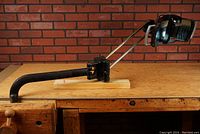 Side view of the Wilmot Castle Panovision dental light with articulated arm and wall mounting bracket attached to a wooden surface.