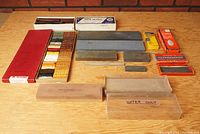Overview of lot on wooden tabletop showing shellac sticks and sharpening stones