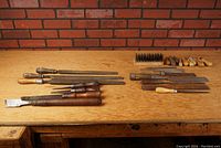 Overview of lot on wooden surface showing chisels, files, wire brush, and wooden handles.
