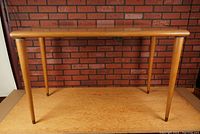 Front view of vintage Mid Century Modern table showing the rectangular top and four tapered legs.
