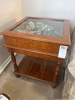 Side view of vintage end table with closed glass top showing wood finish and legs