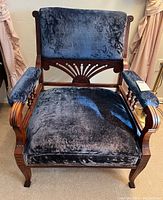 Front view of Victorian Eastlake style armchair with plush blue velvet cushions and carved wooden frame.