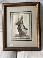 Full view of the framed painting of a monk or friar in brown robes, showing the entire artwork and frame.