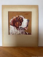Painting of a Saint Bernard dog head in profile with brown and white fur, mounted on a discolored mat board.