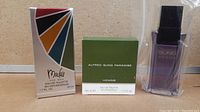 Photo showing all three men's fragrances with their boxes: Mackie for Men, Alfred Sung Paradise Homme, and Sung Homme in its plastic sleeve.