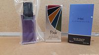 Three men's fragrances displayed: Mackie in original colorful box, Hei in blue box, Sung Homme purple bottle sealed in plastic.