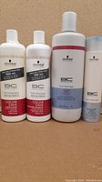 Four bottles of Schwarzkopf Professional BC Bonacure hair therapy products including Color Save Conditioner, Color Save Shampoo, and Moisture Kick Shampoo in various sizes.