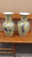 Front view of both vases side by side on wooden bench