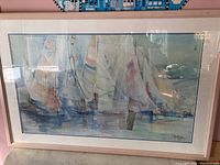 Framed and matted nautical themed print showing sailing boats with soft pastel sails on calm water.
